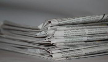 A close-up image of folded newspapers, perfect for news or journalism themes.